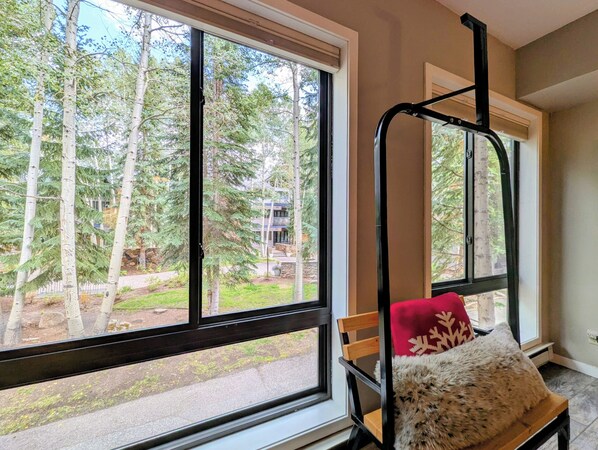 A room with a large window offering a view of trees and a building outside.