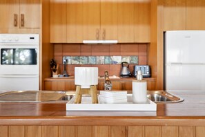 A modern kitchen with wooden cabinets, a stainless steel sink, and a built-in oven.