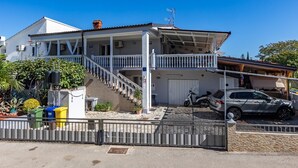 A two-story house with a balcony, a staircase, and a garage.