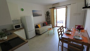 A compact living space with a kitchenette, a dining area, and a sofa.