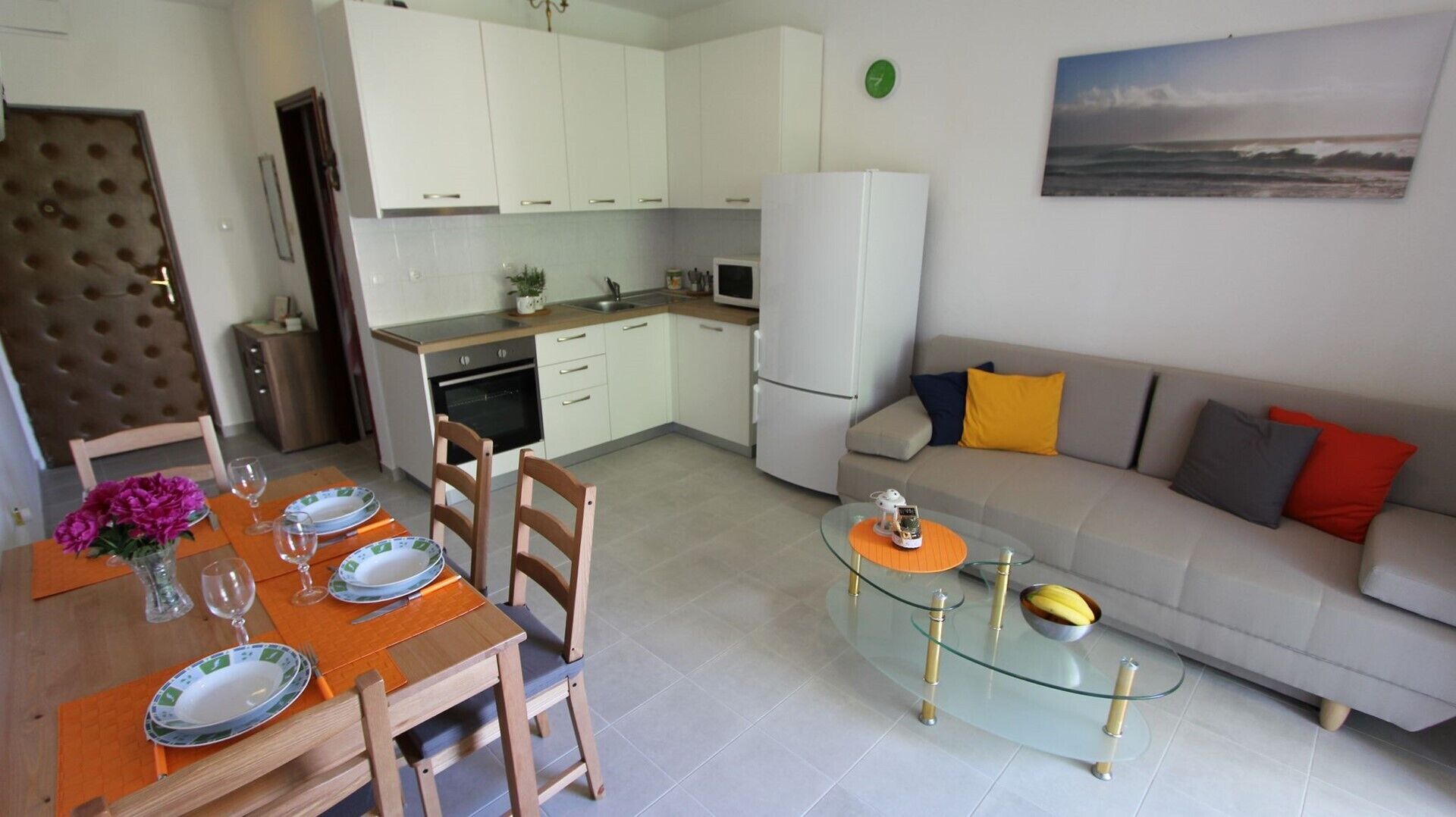 A modern apartment with a dining area, kitchen, and living room.