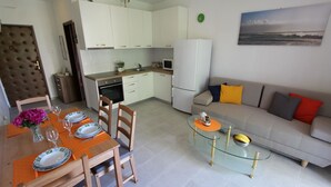 A modern apartment with a dining area, kitchen, and living room.