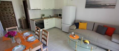 A modern apartment with a dining area, kitchen, and living room.
