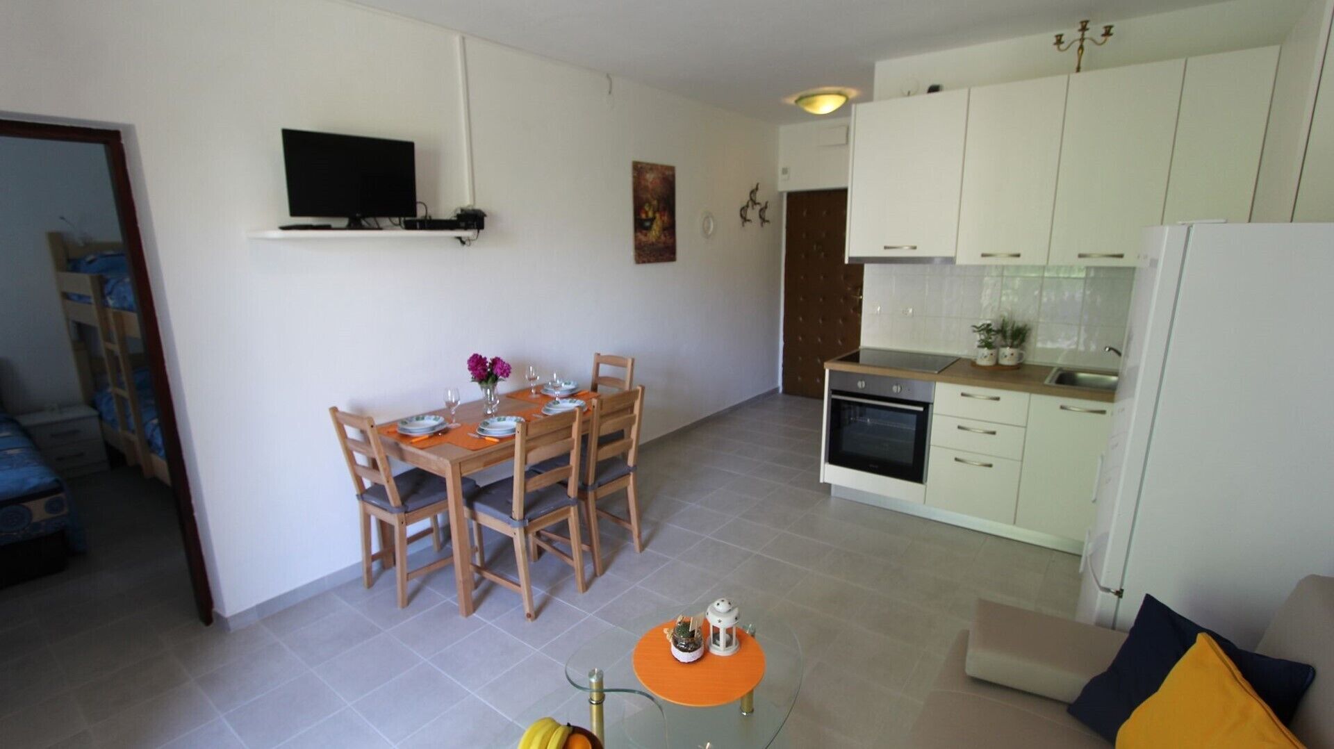 A compact living space with a dining area, a kitchenette, and a small seating area.