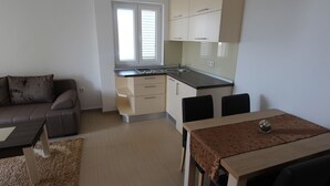 A compact living space with a kitchenette, a dining area, and a sofa.