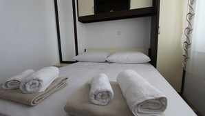 A hotel room with a bunk bed, two pillows, and three rolled towels on the bed. - Deluxe apartment Jela 2 for 4 people with sea view (Sveti Vid Miholjice)