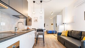 Una cocina moderna con una isla central, electrodomésticos de acero inoxidable e iluminación colgante.