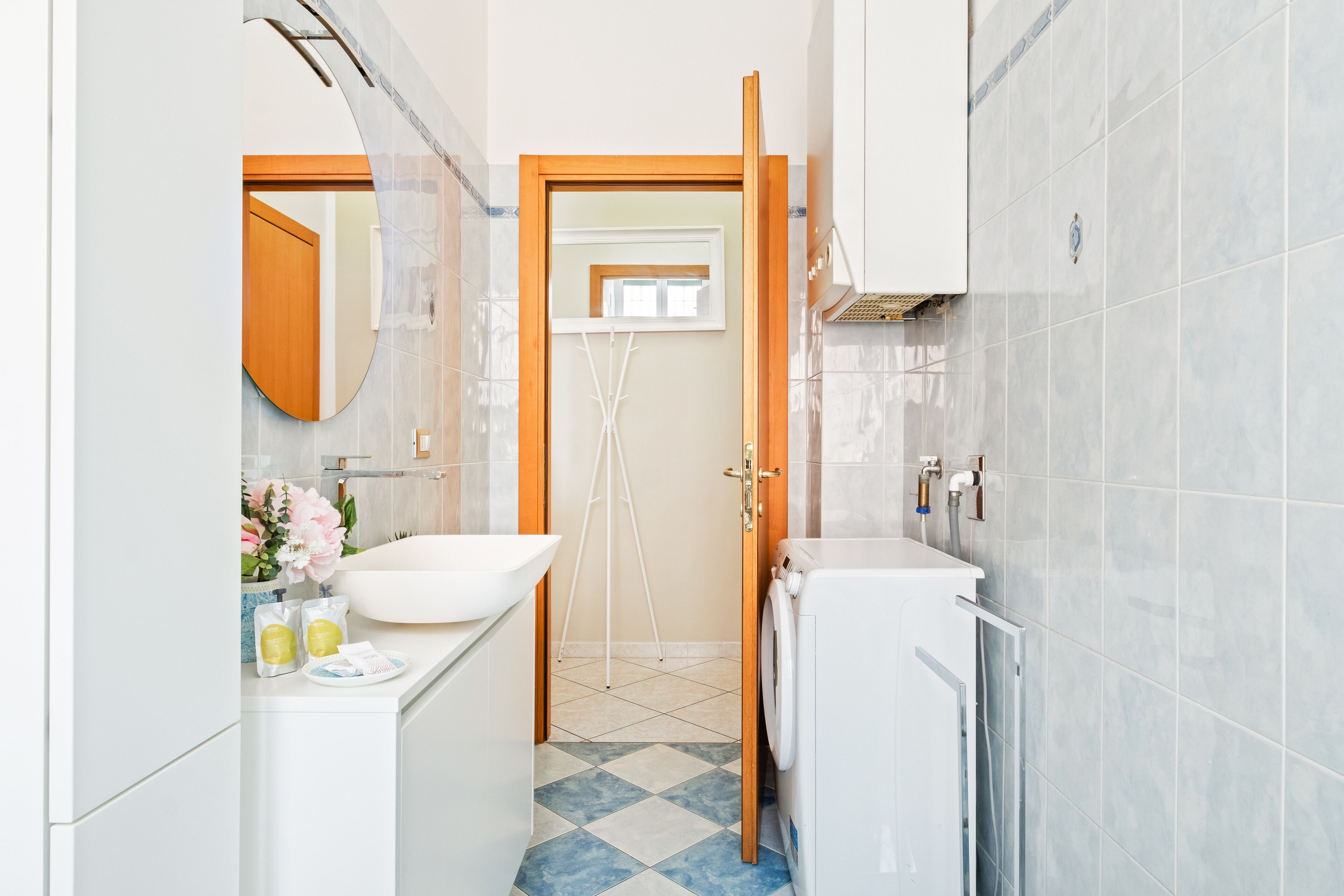 A compact bathroom with a sink, mirror, and a shower area.