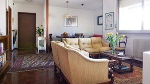 A living room with a sofa, a coffee table, and a bookshelf. - Apartment Surrounded by Greenery (Parma)