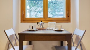 Een tafel met een koffiepot, kopjes en een bordje.
