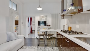 Een moderne keuken met een gasfornuis, barstoelen en een eethoek.