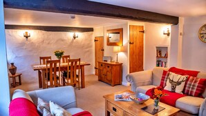 Ein gemütliches Wohnzimmer mit Essbereich, Holzmöbeln und einem Kamin.