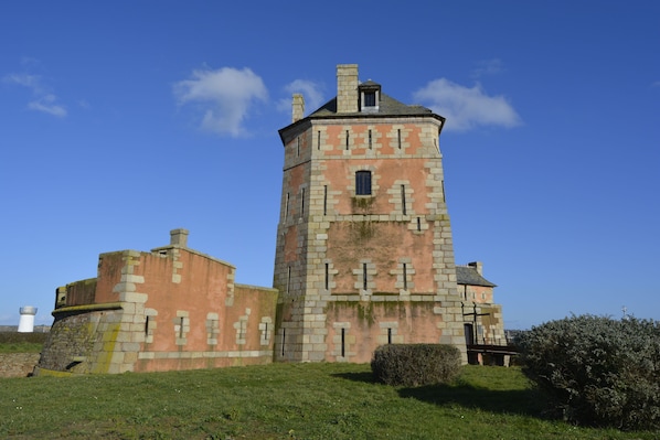 A historic stone building with a tower, featuring a turret and a small window.