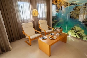A room with two wooden chairs, a wooden table, a bowl, and a plate with food.
