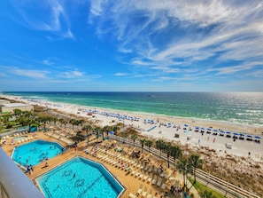 A beach resort with a swimming pool, beach umbrellas, and a view of the ocean. - ​Beachfront Condo! FREE Beach Service, 8th Flr View, Fireplace, Pools, Tootsie's (Panama City Beach)