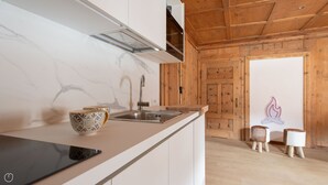 Une cuisine moderne avec un dosseret en marbre, un évier en acier inoxydable et un plafond en bois.