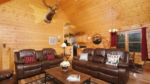 Een gezellig cabin interieur met twee leren banken, een bijzettafeltje en een opgehangen hert.