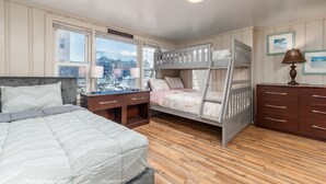 Un dormitorio con una cama litera, un escritorio y un aparador.