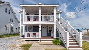 A two-story house with a front porch, a staircase, and a mailbox. - Spacious 3BR apartment 213B near Boardwalk and the Beach (Ocean City)