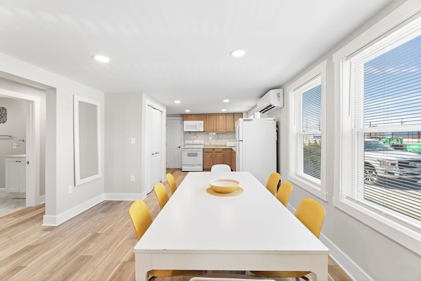 Enjoy meals in the dining area with a white table and comfortable chairs.