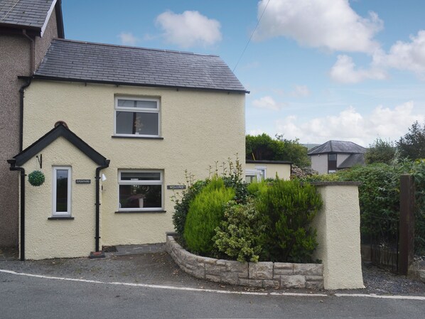 A two-story house with a white exterior, a black roof, and a small front garden. - 2 bedroom accommodation in Bryncrug, near Tywyn (Bryncrug, near Tywyn)