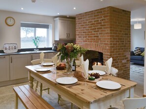A dining area with a brick fireplace, wooden table, and chairs. - 2 bedroom accommodation in Ranby, near Retford (Ranby, near Retford)