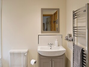 A bathroom with a white sink, a mirror, a towel rack, and a toilet. - 2 bedroom accommodation in Ranby, near Retford (Ranby, near Retford)