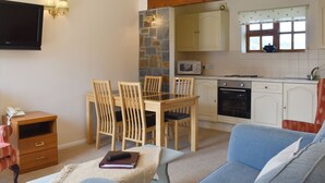 A cozy living room with a dining area, a kitchen with stone accents, and a flat-screen TV. - 2 bedroom accommodation in Sidbury, near Sidmouth (Sidbury, near Sidmouth)