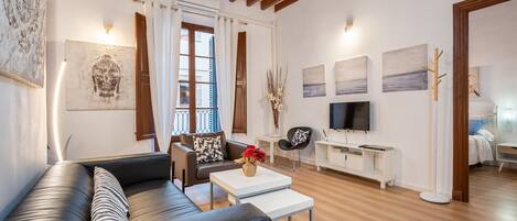 A modern living room with a sofa, coffee table, and artwork on the walls.