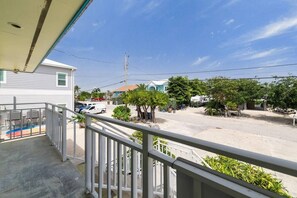 A residential area with a balcony, a swimming pool, and a street view. - Waterfront Home w/ Private Heated Pool & 60` Dock (Marathon)