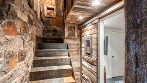 Eine Steintreppe führt zu einer Holztür, mit rustikalem Interieur und einem kleinen Fenster.