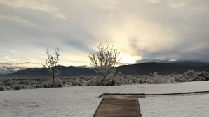 A snow-covered pathway leading to a view of distant mountains.