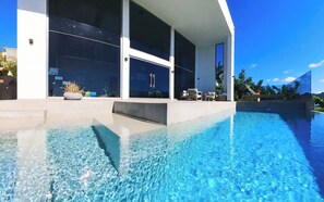 A modern house with a swimming pool, large windows, and outdoor furniture. - SEA TRUE VILLA ,NEW EDIFICE 2021, LAVISH ! (Sint Maarten)