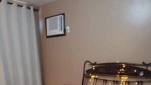 Una camera da letto con un letto, un comodino, una sedia e un punto luce a parete.