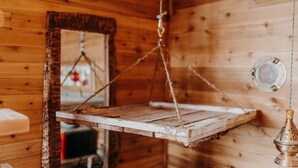 A rustic wooden interior with a hanging wooden shelf and a metal container. - Perch small · Treehouse-Eagles Perch over the water (Port Angeles)