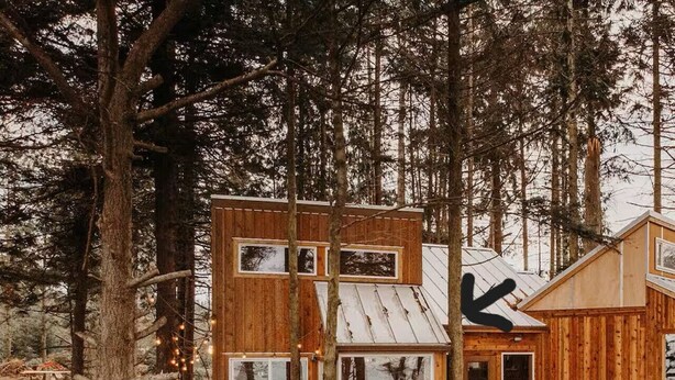 A wooden cabin with multiple levels, large windows, and a deck area. - Perch small · Treehouse-Eagles Perch over the water (Port Angeles)