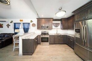 Kitchen features a central island with seating and stainless steel appliances.