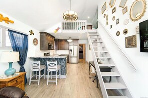Kitchen features a central island, white cabinetry, and stainless steel appliances.