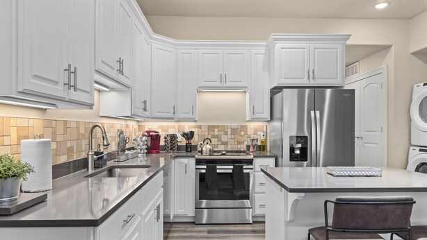A modern kitchen with white cabinets, stainless steel appliances, a central island, and a built-in oven. - Work Here!! King Bed, 400+ Mbps WiFi, BYU (Provo)