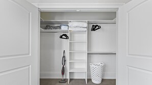 A white closet with shelves, a hanging rack, and a vacuum cleaner. - Work Here!! King Bed, 400+ Mbps WiFi, BYU (Provo)