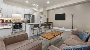 A modern kitchen with white cabinets, stainless steel appliances, and a central island with bar stools. - Work Here!! King Bed, 400+ Mbps WiFi, BYU (Provo)