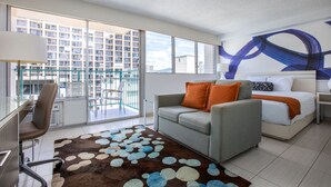 A modern hotel room with a balcony, a sofa, a bed, and a desk. - Aqua Aloha Surf Waikiki 1008 | City Views – Pool & BBQ (Honolulu)