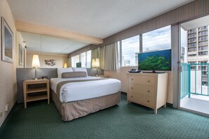 A hotel room with a bed, bedside tables, a TV, a dresser, and a balcony with a view of the city.