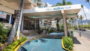 A hotel with a pool area, palm trees, and a sign reading "AQUA ALOHA SURF". - Aqua Aloha Surf Waikiki 304 | City Views – Pool & BBQ (Honolulu)
