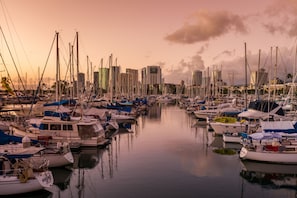 A marina with numerous boats docked, surrounded by high-rise buildings.