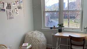A cozy room with a wooden floor, a large window with a view of the outside, a radiator, and a chair. - Stylish 1 bedroom apartment, walking distance to Georgetwon (Arlington)