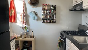 A compact kitchen with a black and white checkered floor, a spice rack, and a stove. - Stylish 1 bedroom apartment, walking distance to Georgetwon (Arlington)