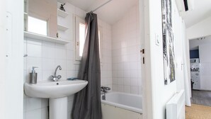 Ein Badezimmer mit einem weißen Waschbecken, einer Badewanne und einer Duschvorhang.