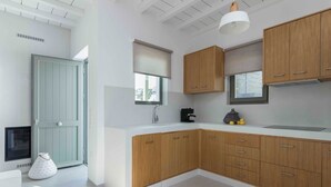 Una cocina moderna con armarios de madera, encimera blanca y horno empotrado.