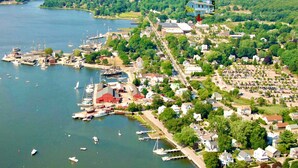 Vue aérienne d’une ville au bord d’un lac, avec des maisons résidentielles, un port de plaisance et des bateaux.